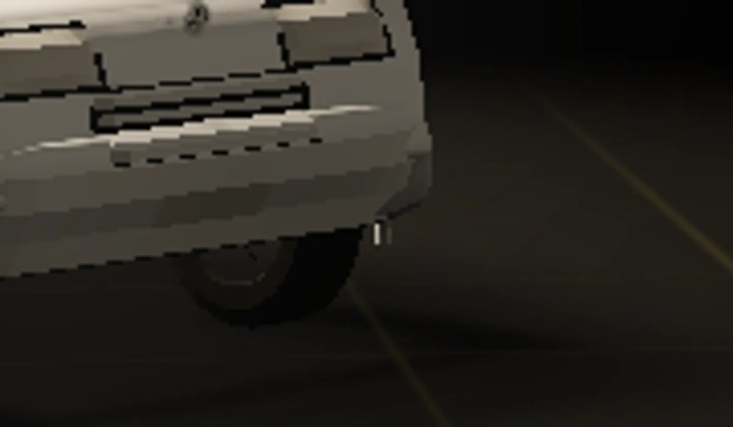 An eight times magnification of the front bumper corner: a short bright white bar floats in the dark just past the bumper's edge, touching nothing